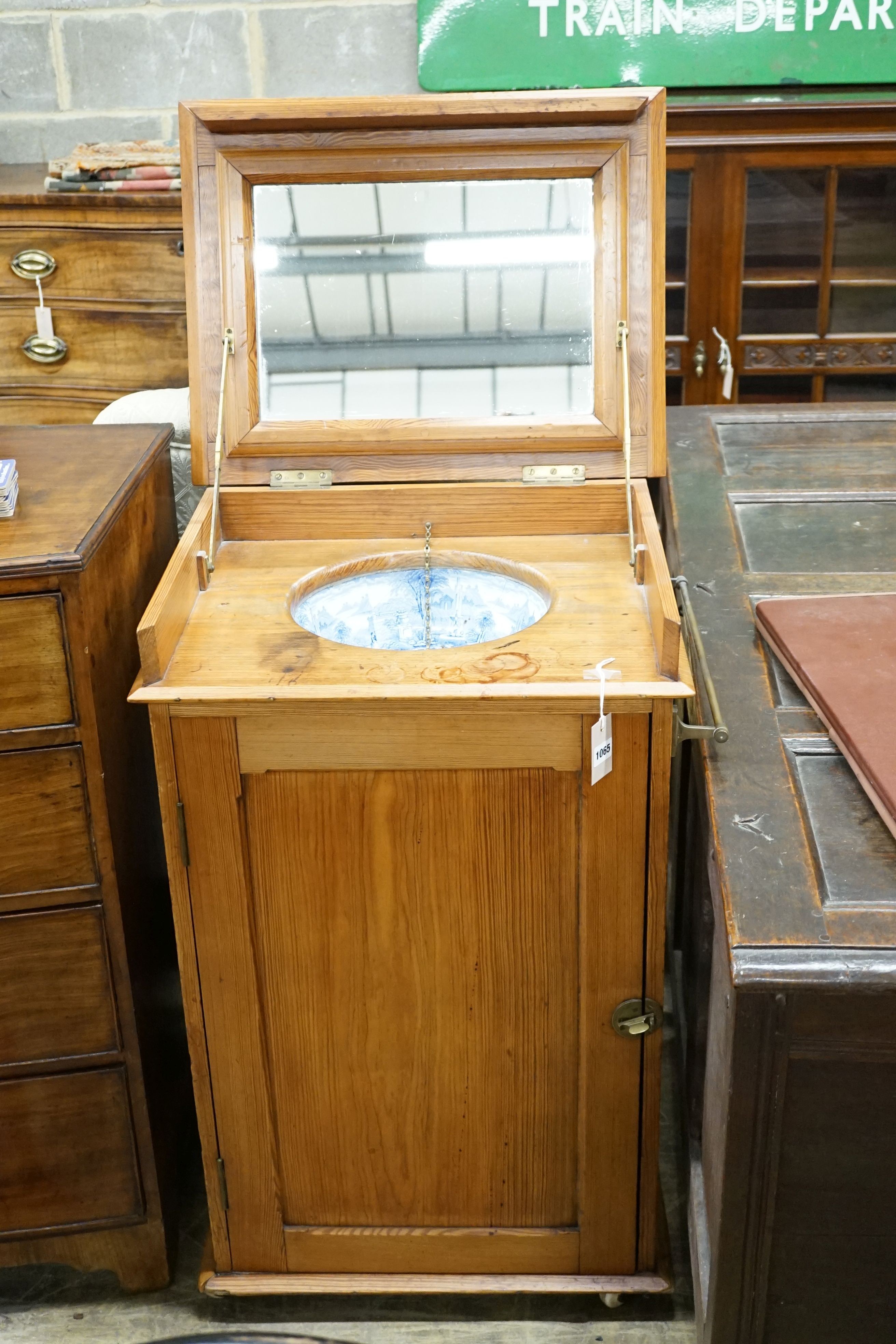 A late Victorian pitch pine wash stand with mirrored folding lid and blue and white printed basin (a.f.), width 58cm